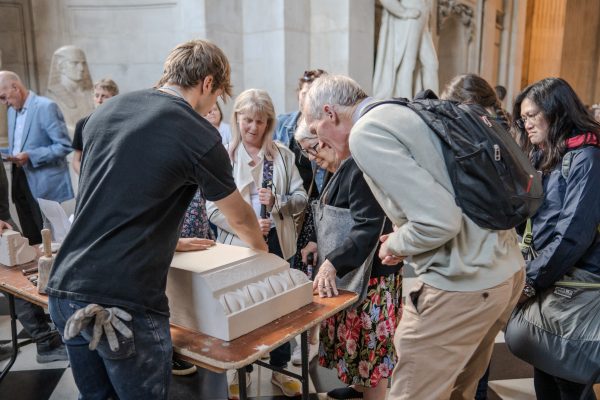 Stoen mason wexplaining the process to visitors inside St Paul's cathedral